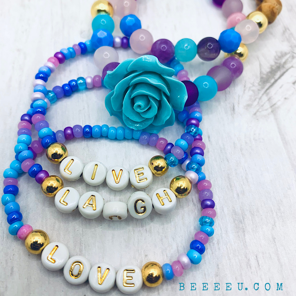 beeeeu live and laugh love blue purple and pink gold white and gold lettering beads